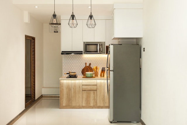 a small kitchen apartment with a green fridge and wooden cabinets