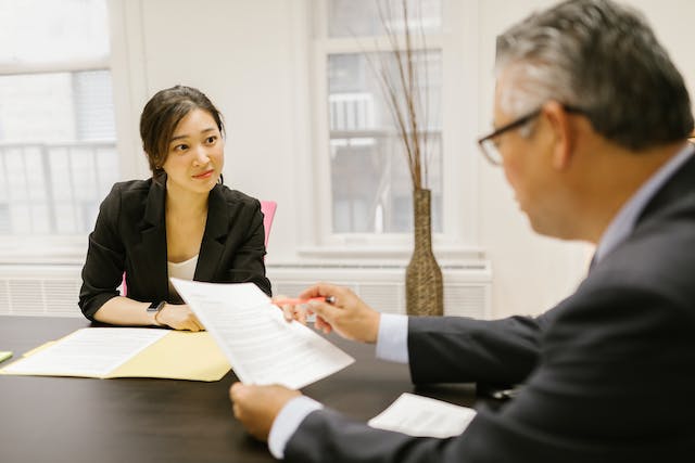 person passing a lease contract to someone else across a table