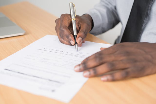 A pair of hands signing a contract.